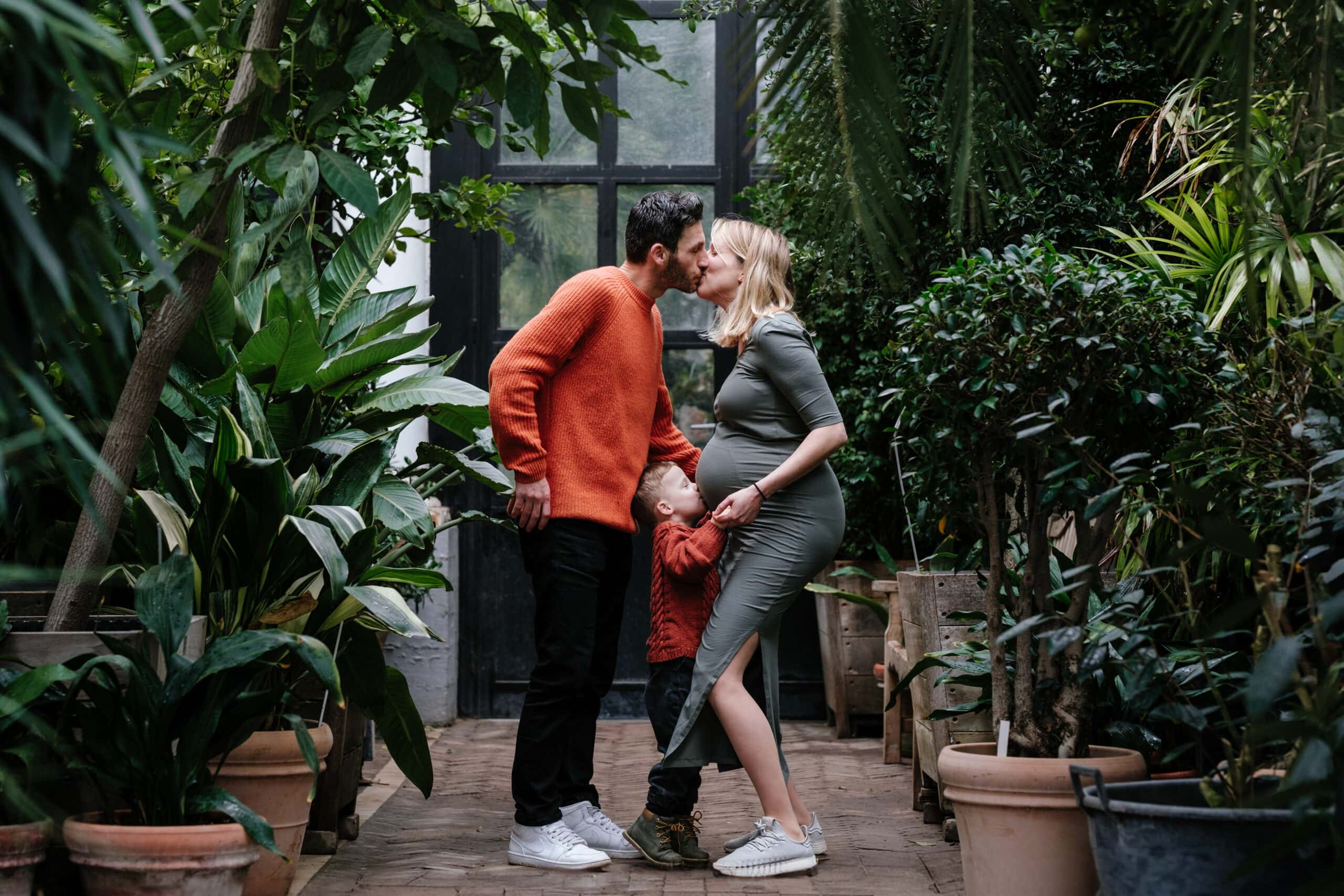 Zwangerschap gezin kust elkaar op schattige manier in de Kruidtuin van Leuven